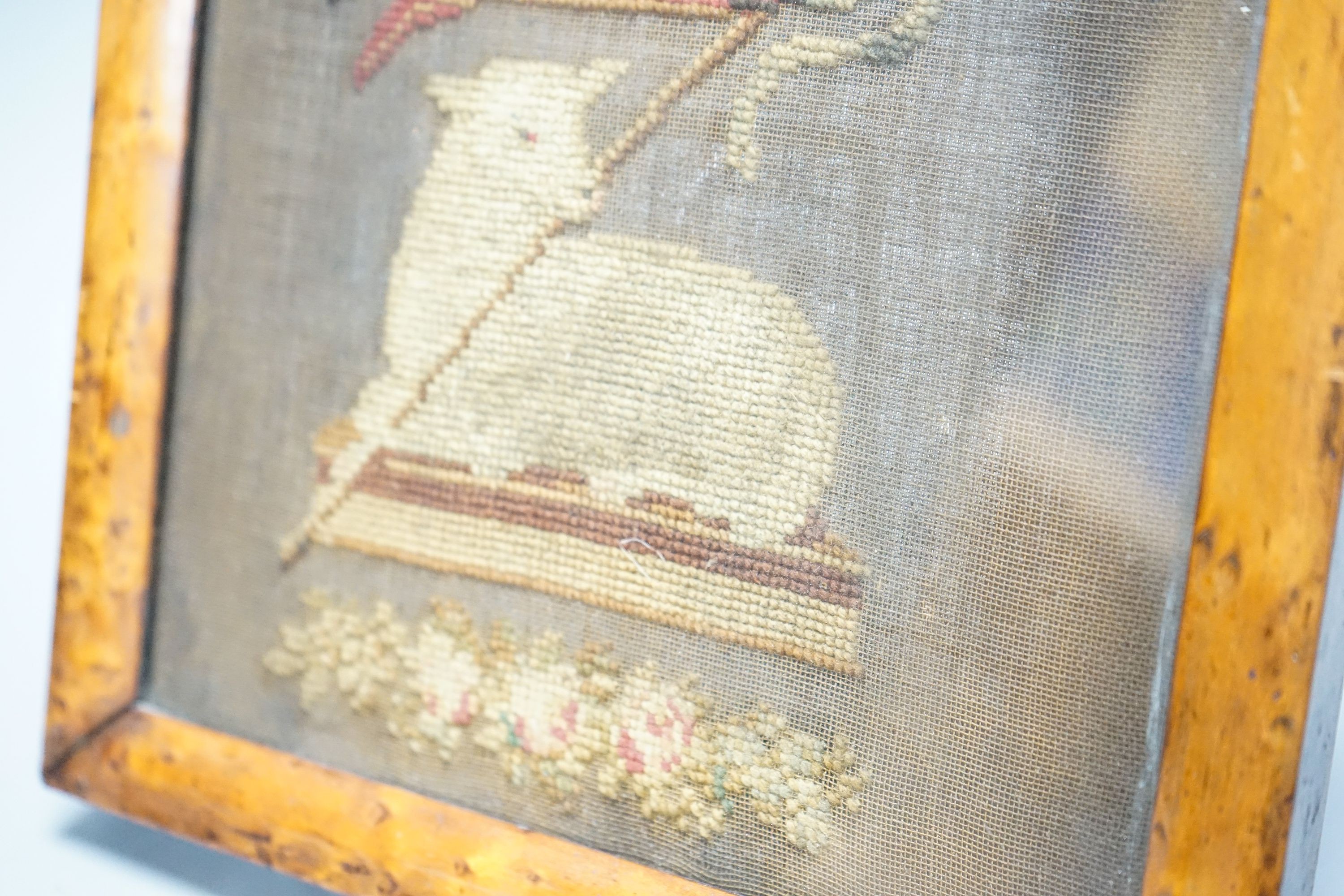 An early 19th century needlework of the Agnus Dei with the vexillum, incorporating a lamb and flag, in bird's eye maple frame 25x23cm incl frame